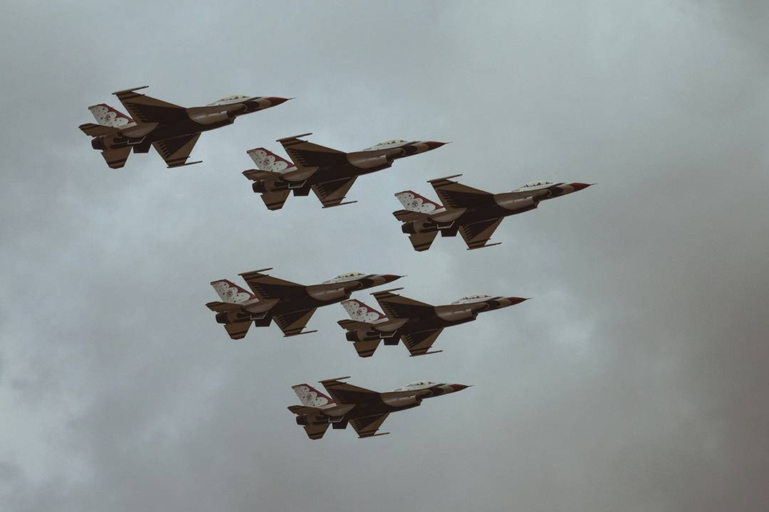 Image of fighter jets in formation flying across sky cloudy sky