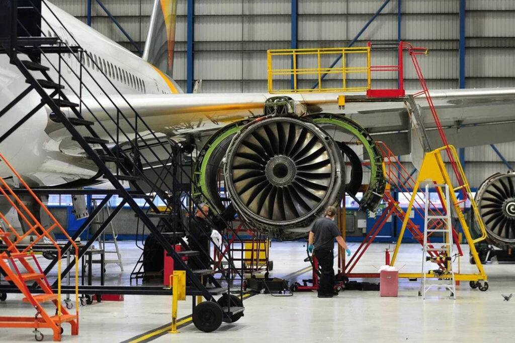 Engineers performing safety checks on airline jet engine